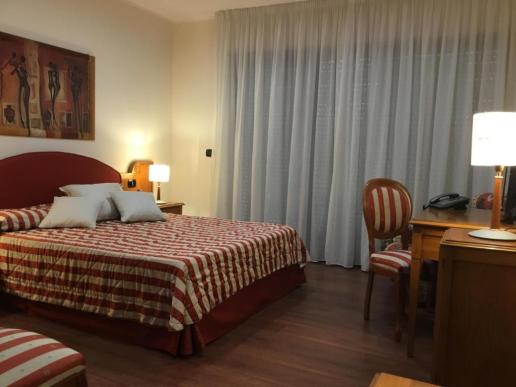 Camera da letto matrimoniale con dettagli rossi.