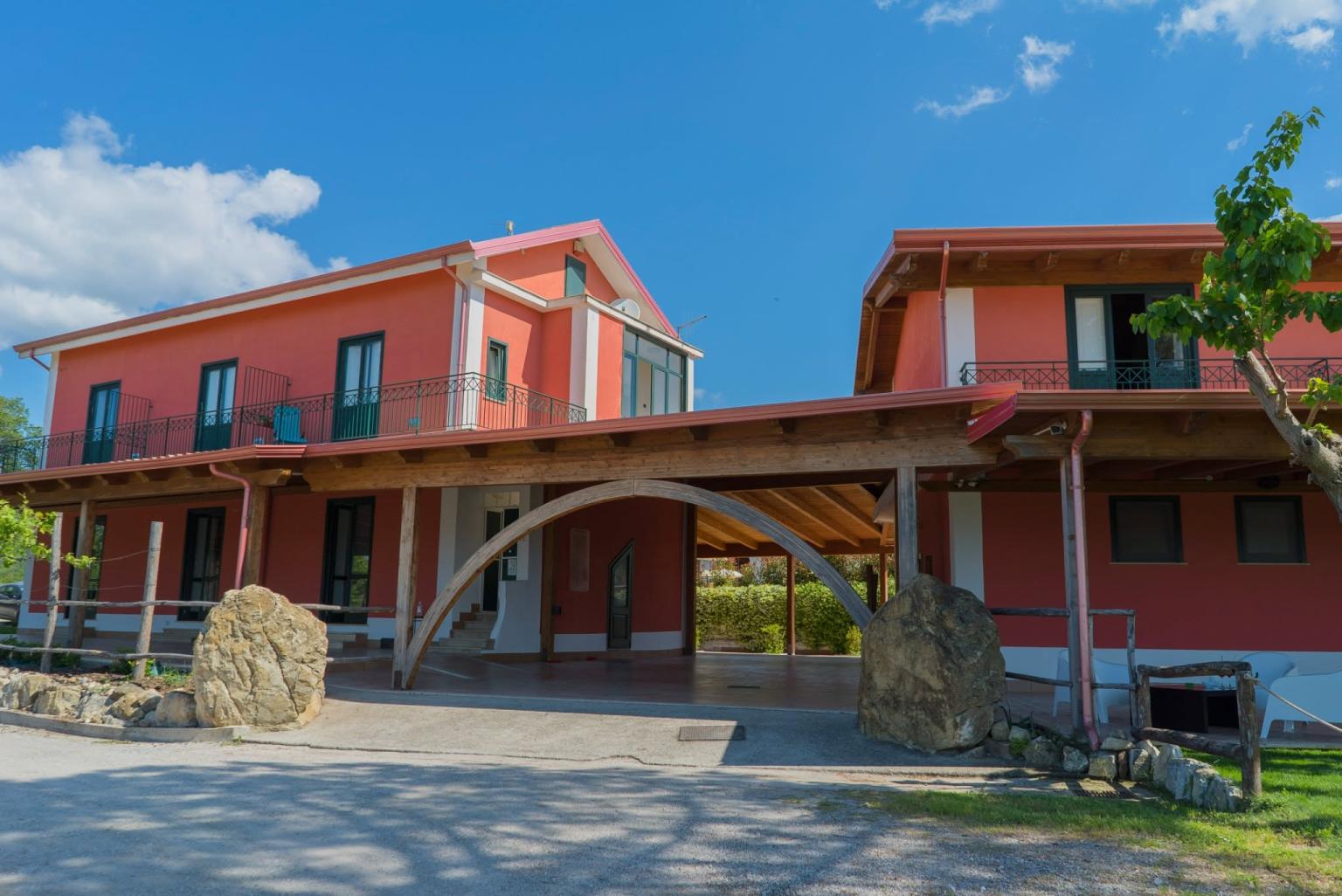 Esterno dell’agriturismo immerso nel verde, con ampio terrazzo.