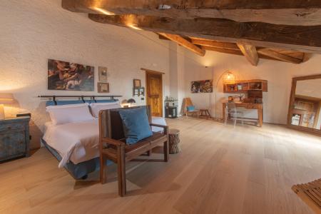 Schlafzimmer im rustikalen Stil mit freiliegenden Holzbalken, Eichenboden, handgefertigten Möbeln und Vintage-Details.