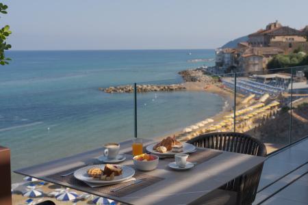Frühstück auf einer Terrasse mit Meerblick, mit Kaffee, Croissants und Gebäck.