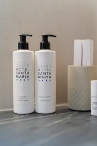 Badezimmer-Spender des Grand Hotel Santa Maria mit Haarspülung und Flüssigseife sowie Toilettenartikeln und Körperpflegeprodukten in einem eleganten Hotelambiente.