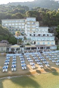 Hotel direkt am Meer mit eigenem Strand, ausgestattet mit Sonnenschirmen und Sonnenliegen.